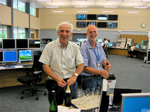 Frédérick Bordry, chef du groupe Convertisseur de puissance, et Roberto Saban, coordinateur de la mise en service du LHC, célébrant au Centre de contrôle du CERN la première mise sous tension d'un secteur du LHC